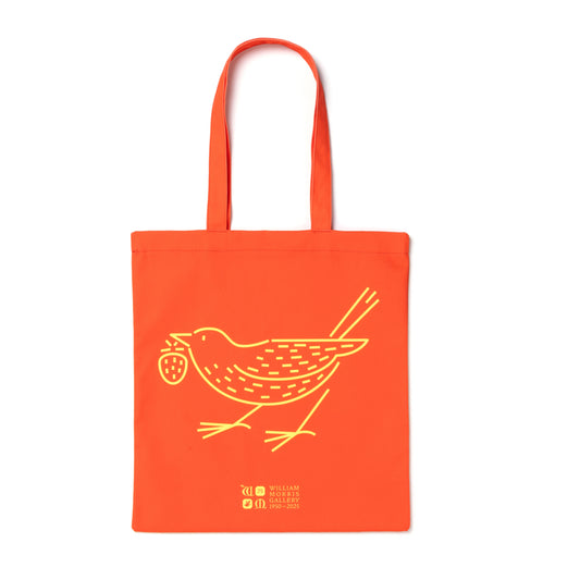 An orange cotton tote bag with a yellow 'Strawberry Thief' design and text printed on the front.