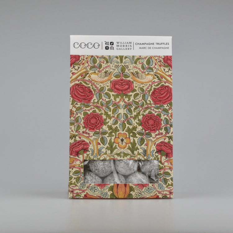 Decorative box with floral design and champagne truffles on a gray background