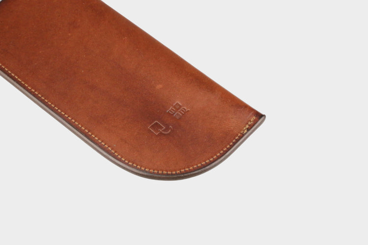 Brown leather case with a brand logo on a light gray background