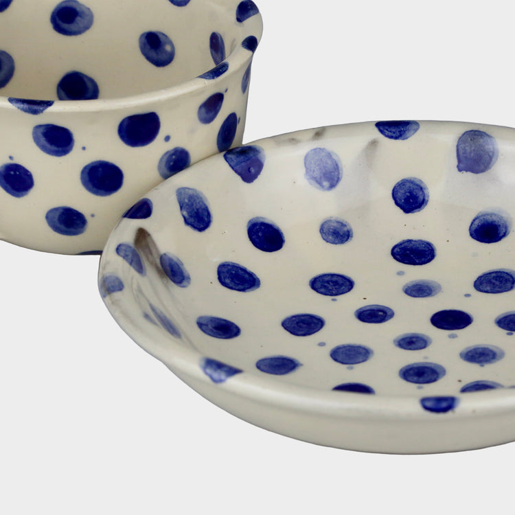 Two ceramic bowls with blue polka dot pattern on a white background