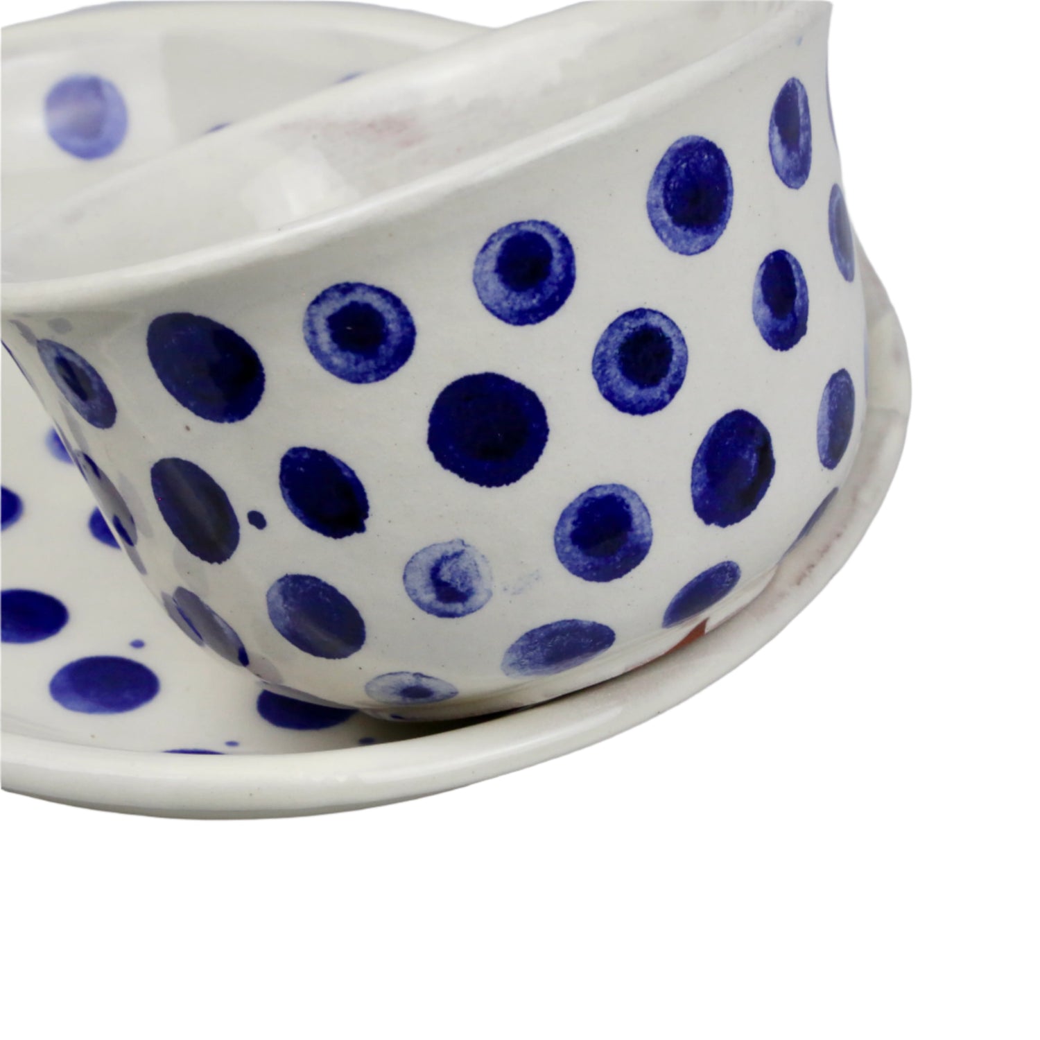 Ceramic cup with blue polka dots on a white background