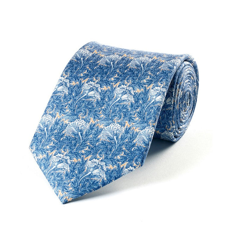 A folded silk tie with a blue floral tulip pattern on a white background, presented in its packaging.