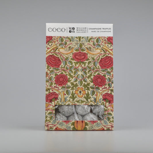 Decorative box with floral design and champagne truffles on a gray background