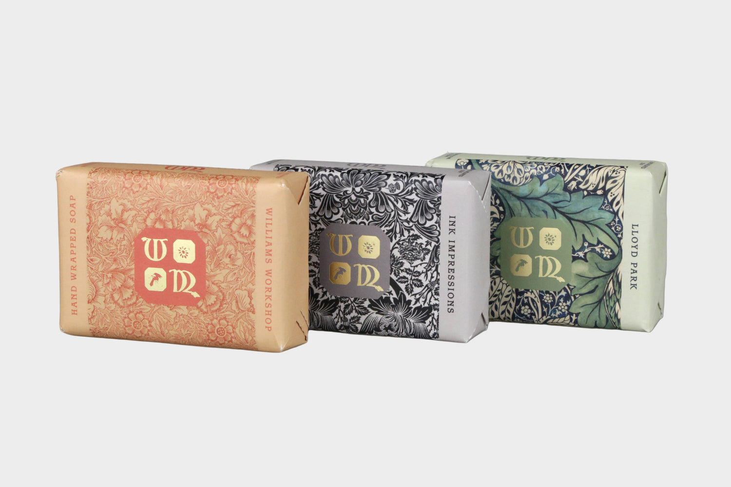 Three bars of soap with decorative packaging on a gray background