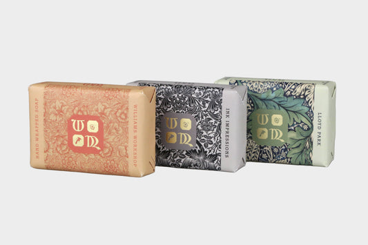 Three bars of soap with decorative packaging on a gray background