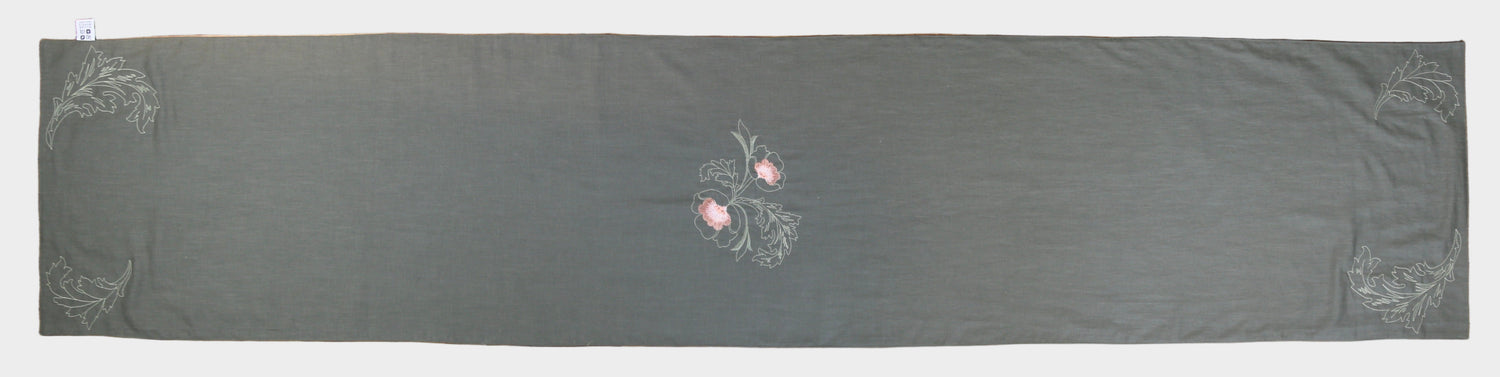 Dark gray fabric with floral embroidery on a wooden surface