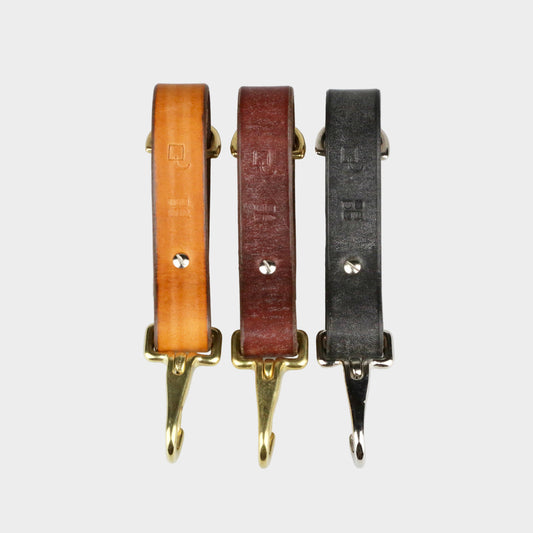 Three leather straps with gold hooks on a white background