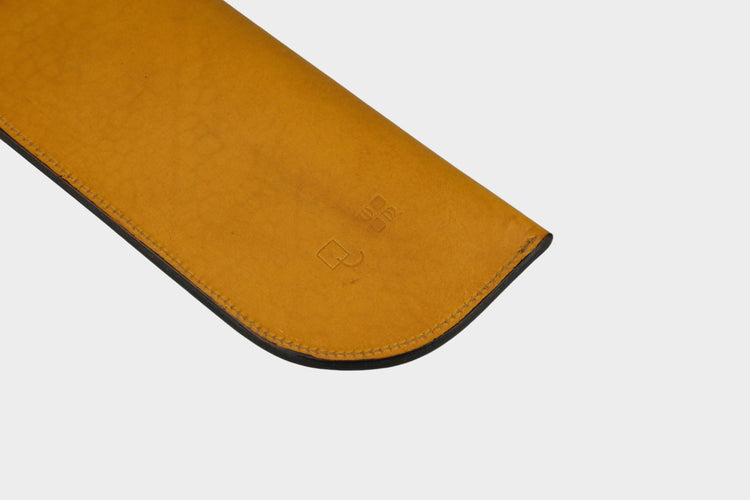 Brown leather mouse pad with brand logo on a gray background