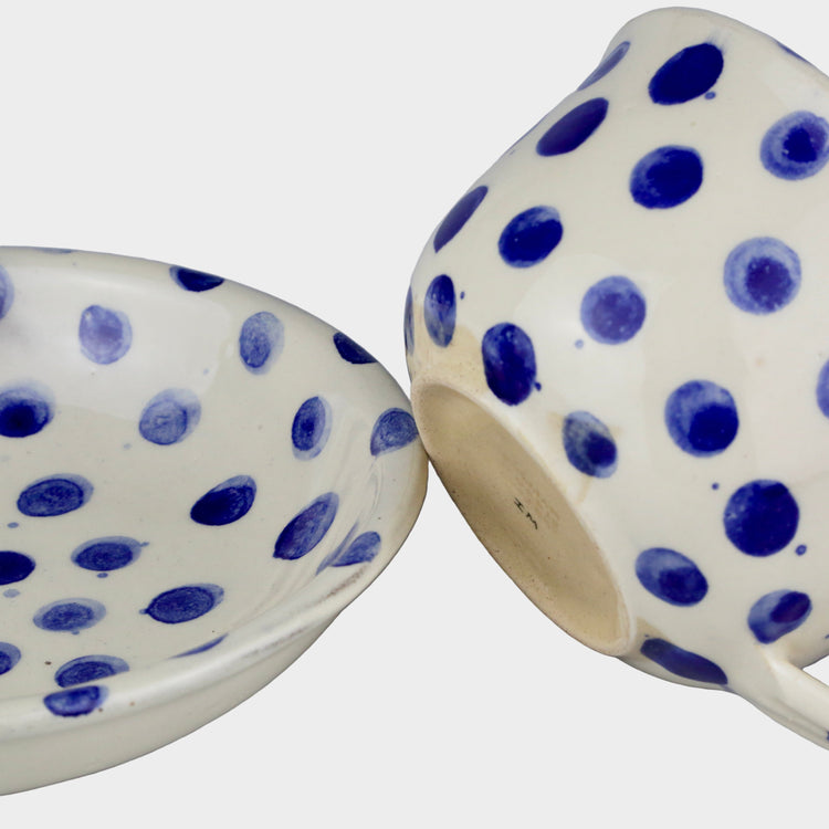 Two ceramic bowls with blue polka dot patterns on a light gray background