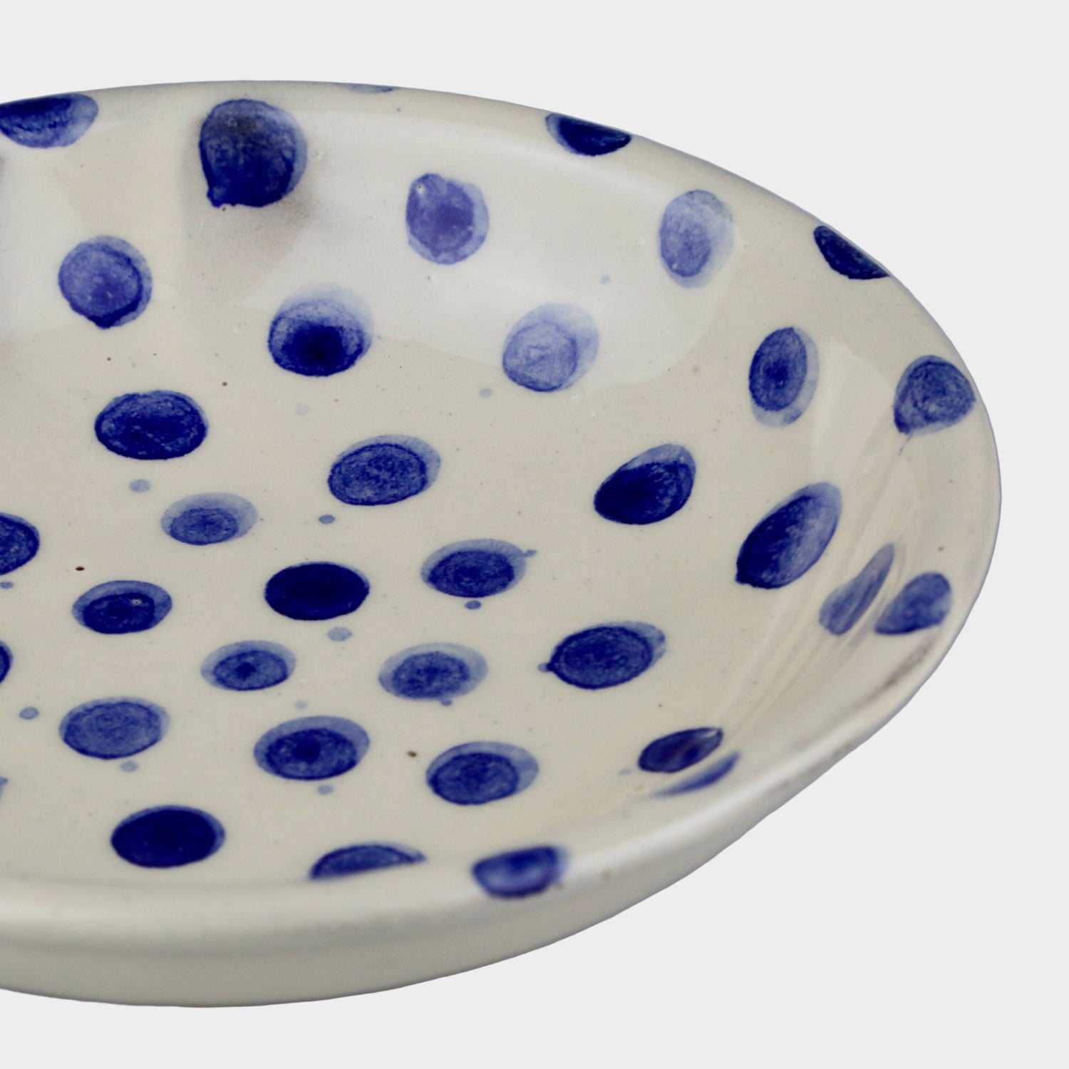 Ceramic bowl with blue polka dot pattern on a gray background