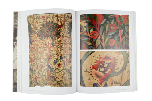 Open book displaying intricate floral and nature-themed illustrations on a gray background