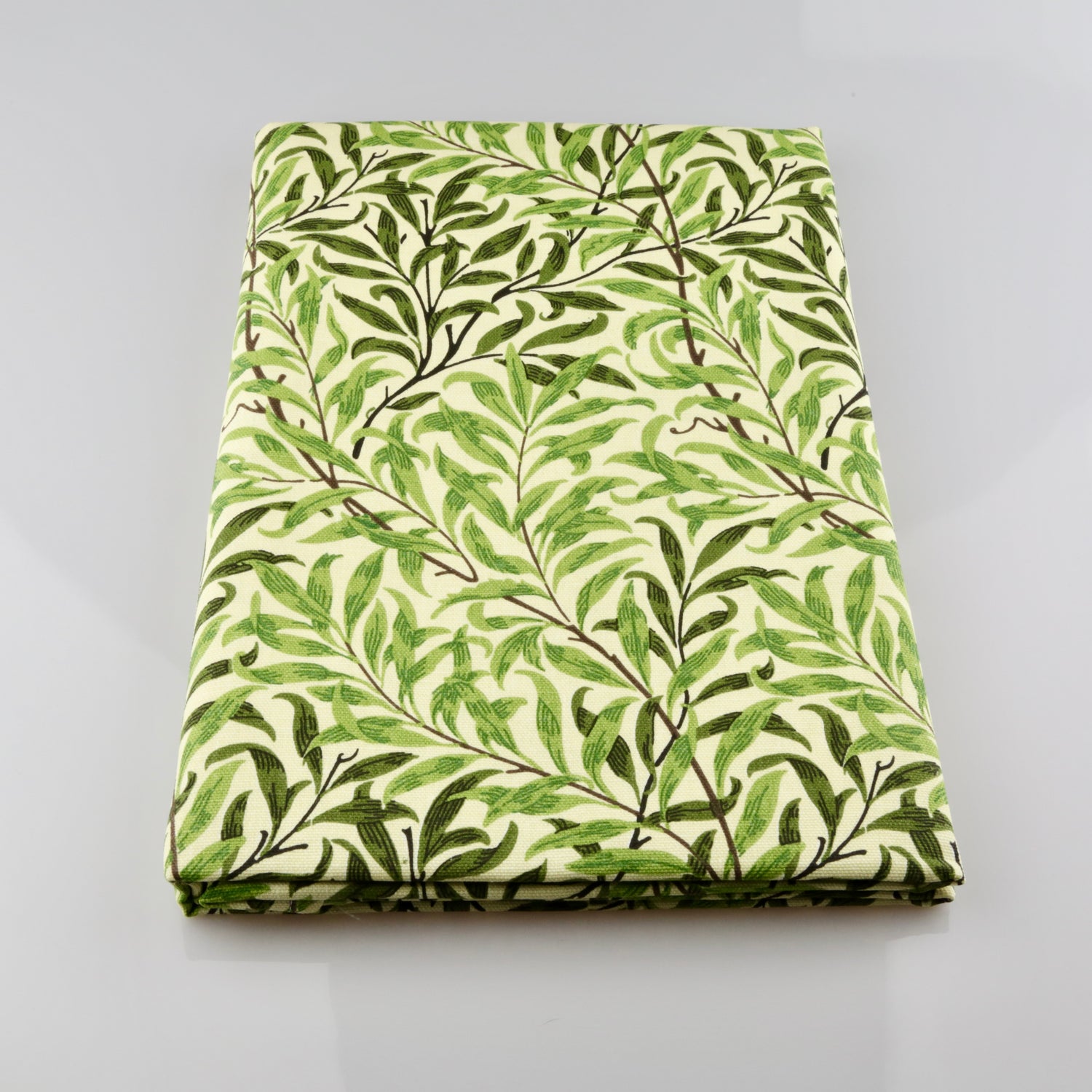 Folded fabric with green leaf pattern on a gray background