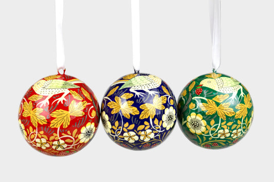 Three decorative Christmas balls with floral patterns on a gray background