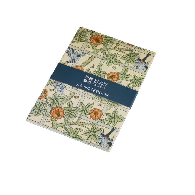 A Moleskote notebook with a William Morris-style floral and bird pattern, wrapped in a dark blue paper band that reads 'MOLESKOTE AS NOTEBOOK', photographed on a neutral gray background.