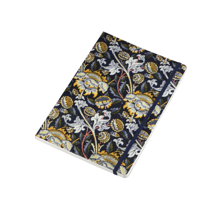 A hardcover notebook with a dark navy blue cover featuring a detailed floral and botanical pattern in gold, white, and light blue, secured with a matching navy elastic band, shown on a neutral light gray background.