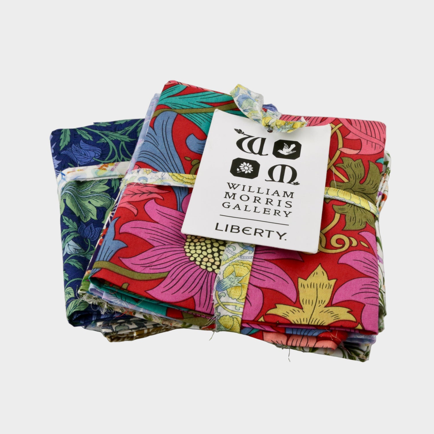 Stack of colorful fabric swatches with a Liberty label on a gray background