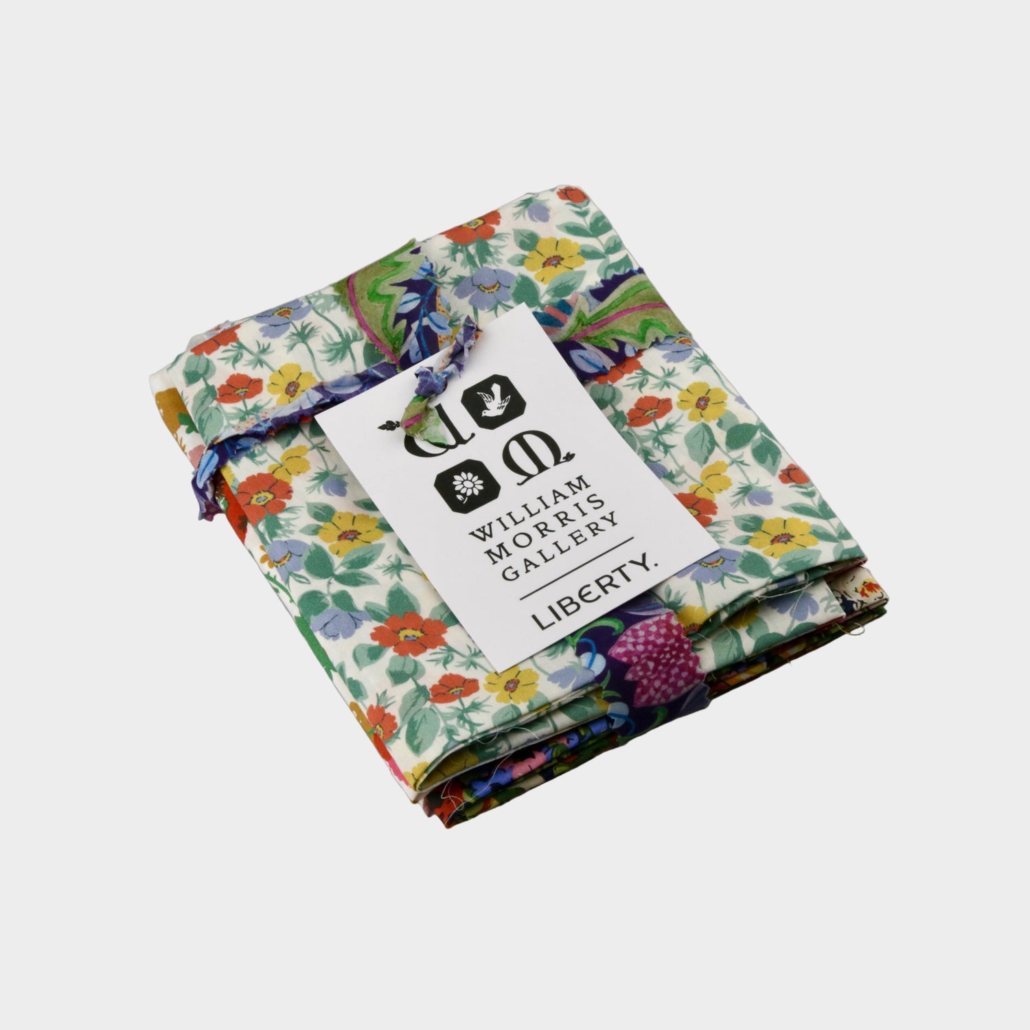 Folded fabric with a Liberty print and William Morris Gallery tag on a gray background
