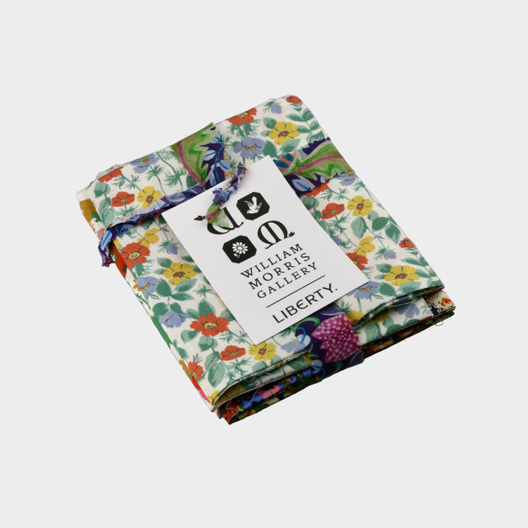 Folded fabric with a Liberty print and William Morris Gallery tag on a gray background