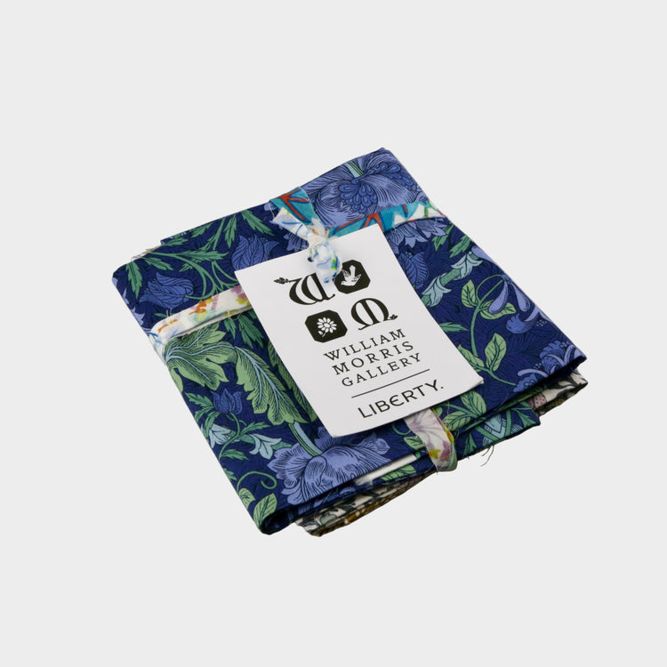 Stack of folded fabric with a Liberty label on a gray background