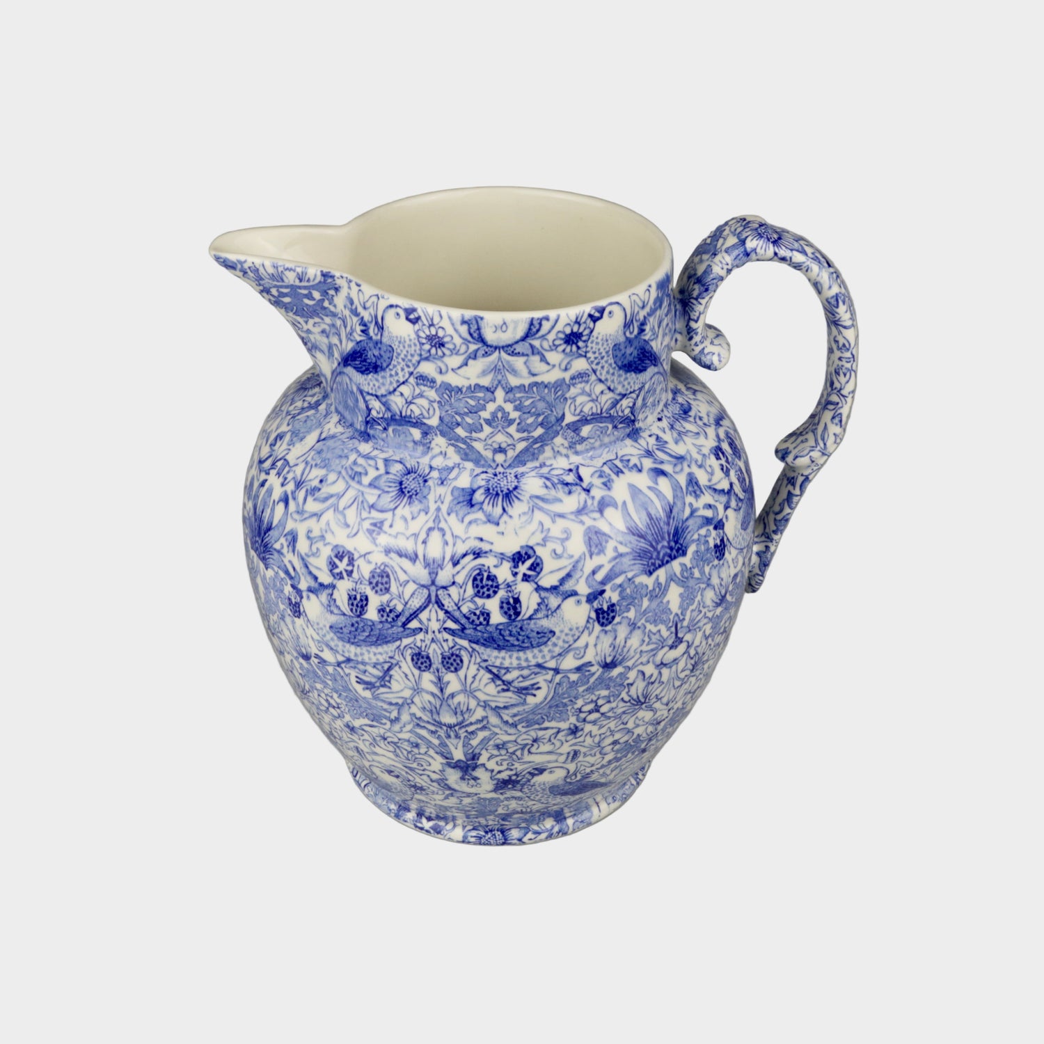 Blue and white ceramic pitcher on a gray background