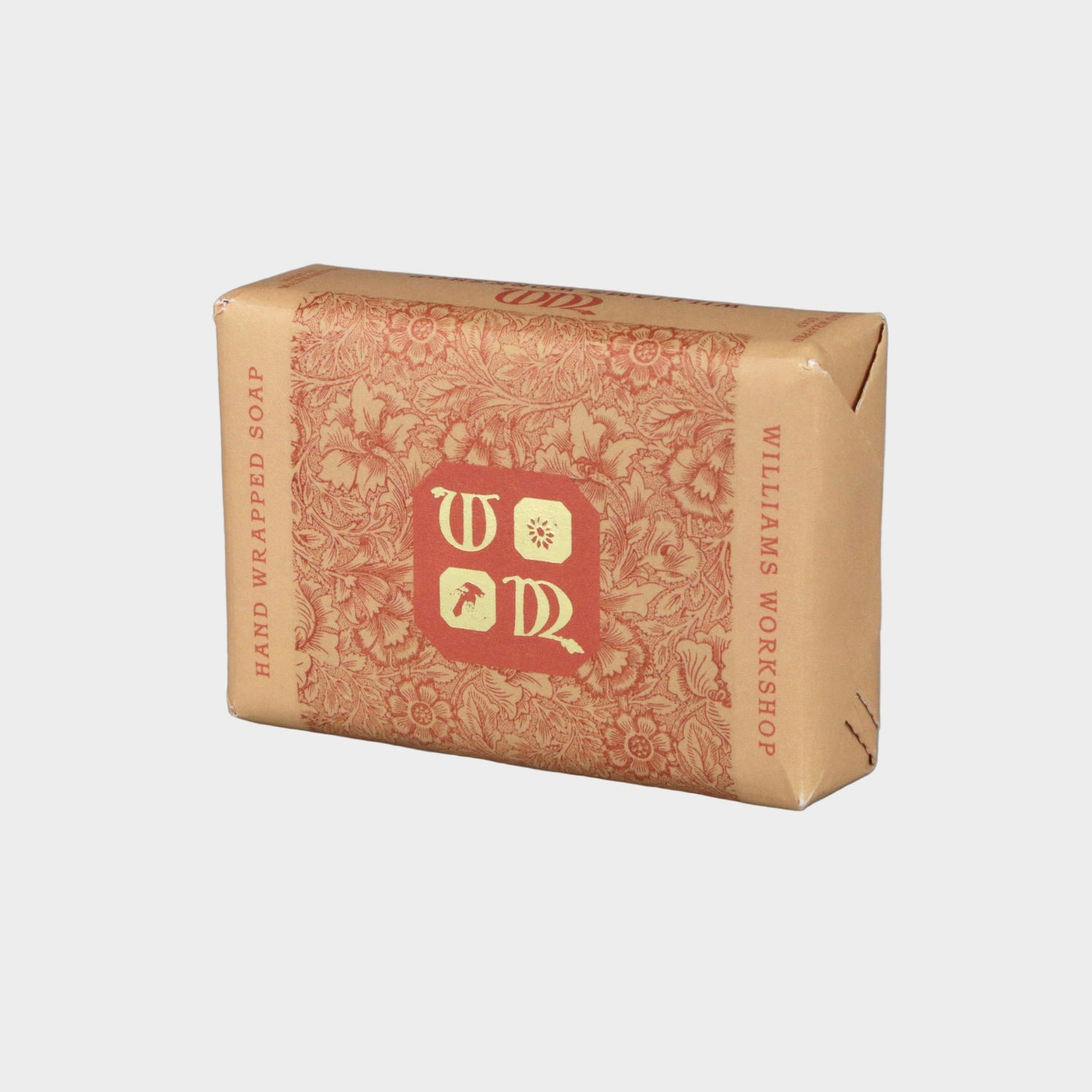 Bar of soap in brown packaging with a logo on a gray background