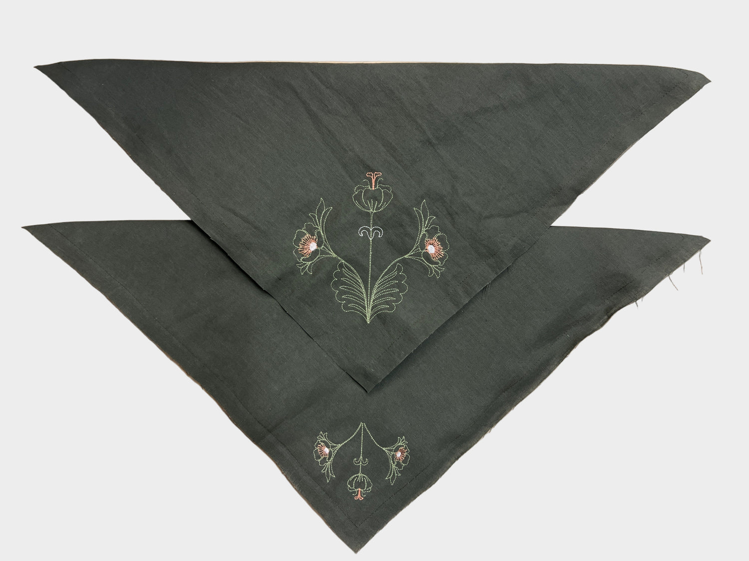 Dark green embroidered napkins on a wooden surface