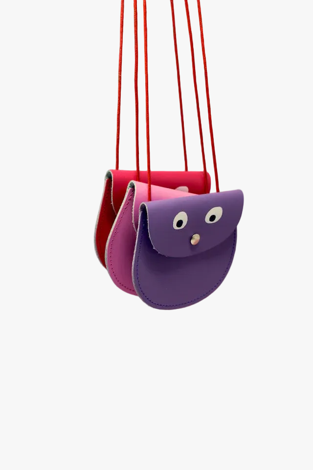 Purple and pink children's swing against a pink background