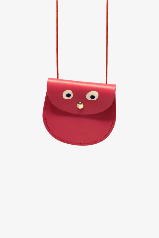 Pink bag with face-like design on a peach background