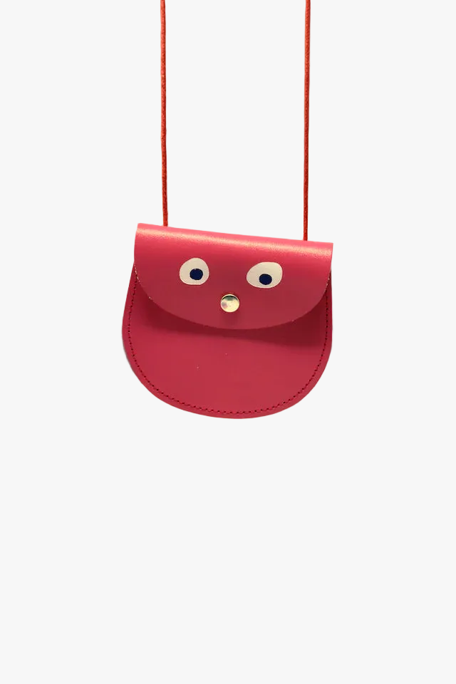 Pink bag with face-like design on a peach background