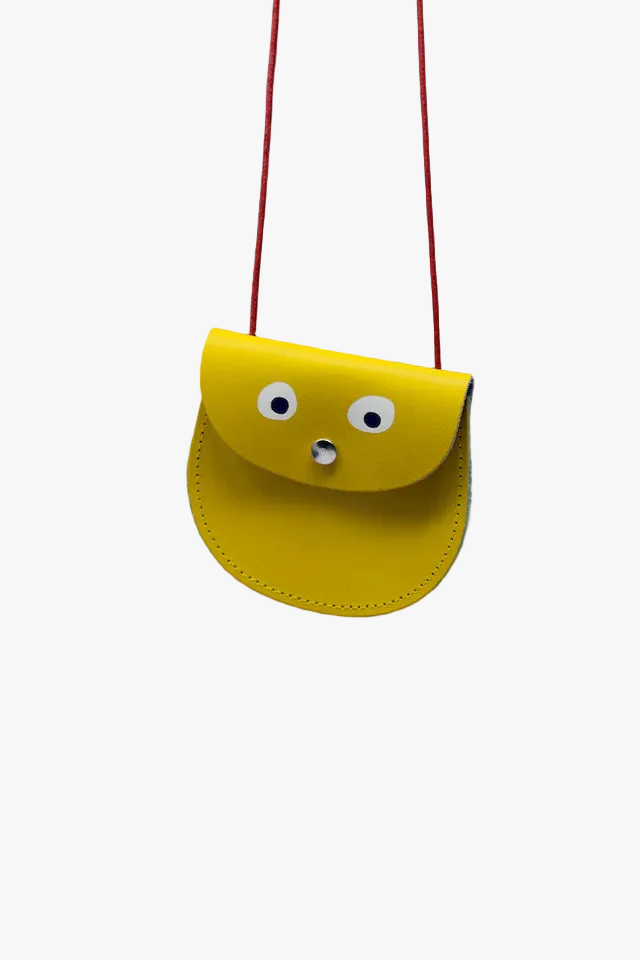 Yellow pouch with googly eyes and a red strap on a white background